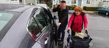 Man Standing with Woman and Walker
